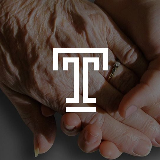 Elderly hand clasped in a youthful hand. The Temple logo is superimposed. 