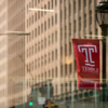 a city street with a Temple flag hanging from a light post