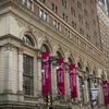 An exterior shot of Terra Hall wioth 5 temple flags for various schools and colleges hanging in front of it. 
