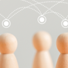 Photograph of wooden figures with connected nodes indicating community.